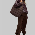 Lieblingstasche Alltime Buddy quilted brown shoulder bag worn by a woman in a matching brown outfit