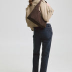 Lieblingstasche Alltime Lover ReSuede M dark brown suede hobo bag worn over the shoulder by a woman in a trench coat