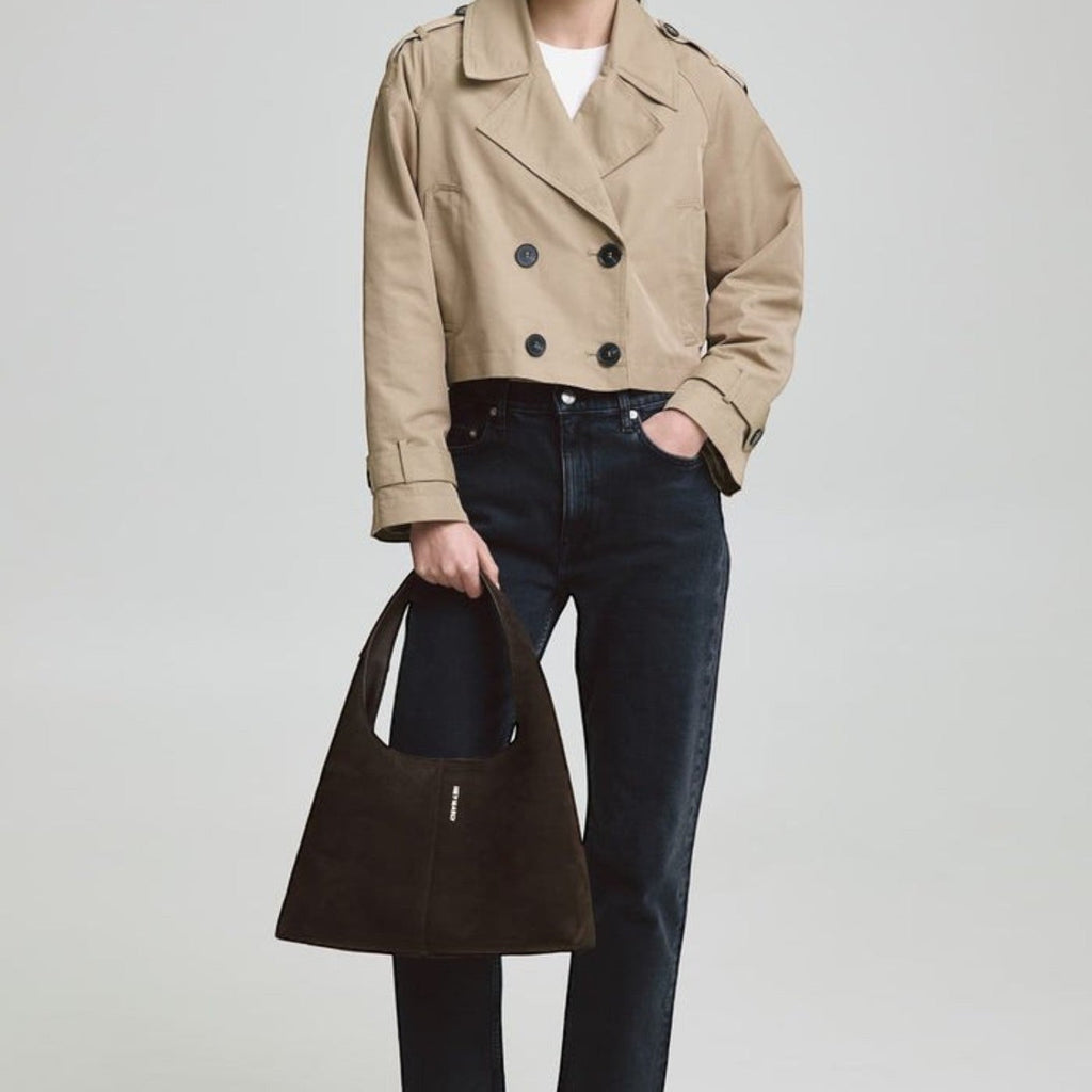 Lieblingstasche Alltime Lover ReSuede M dark brown suede hobo bag held by a model in a beige trench coat