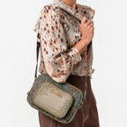 Lieblingstasche Anekke cross-body bag with textured green and brown patterns worn over the shoulder
