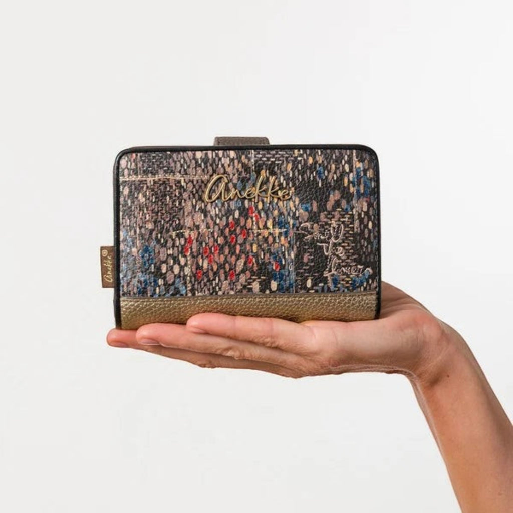 Lieblingstasche Anekke wallet featuring a multi-colored mosaic pattern with gold metallic accents held in a hand