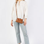 Lieblingstasche aunts & uncles Mrs. Whoopie Pie brown leather crossbody bag worn by a woman in a white blouse