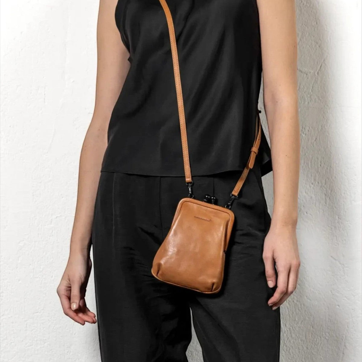 Lieblingstasche aunts & uncles Mrs. Sugar Pop vintage brown leather crossbody bag with clip closure on a model