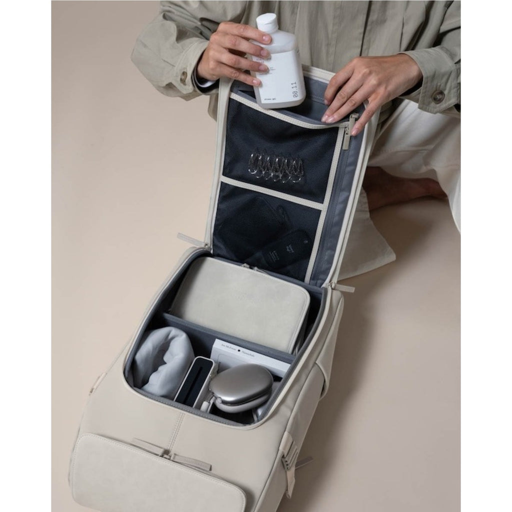 Lieblingstasche Bali Pro beige backpack open showing organized interior with toiletries and tech accessories.