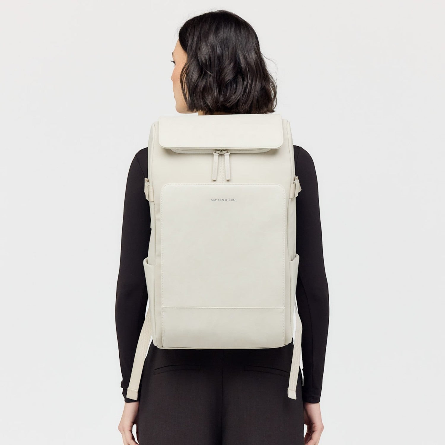 Lieblingstasche Bali Pro light grey vegan leather backpack with multiple pockets and zippers, worn by a woman.