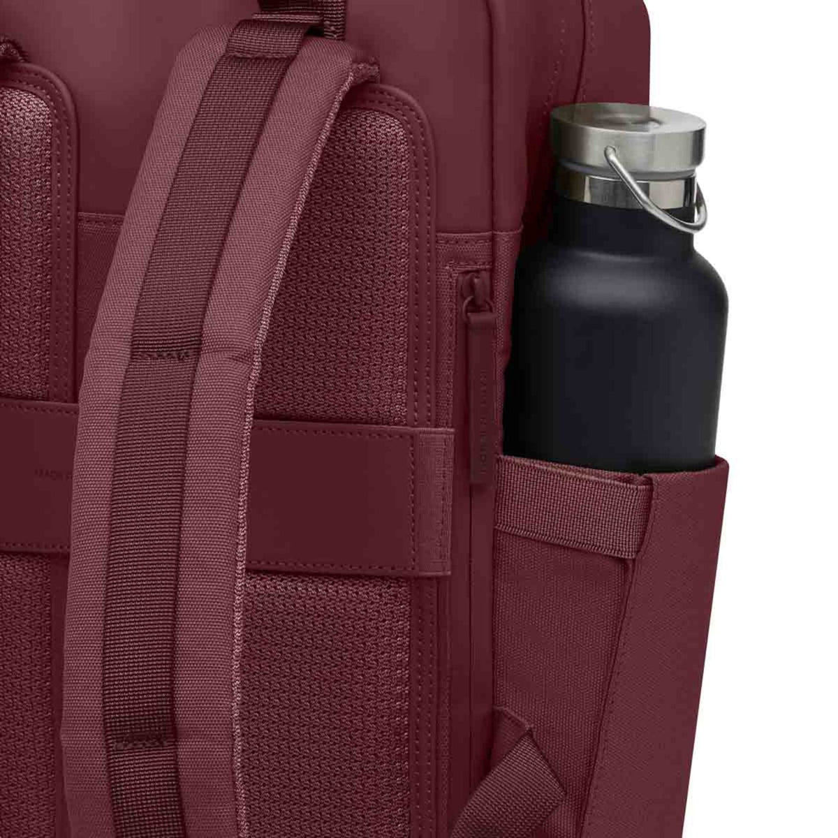 Lieblingstasche Bergen Pro burgundy backpack with padded straps and a side pocket holding a black water bottle