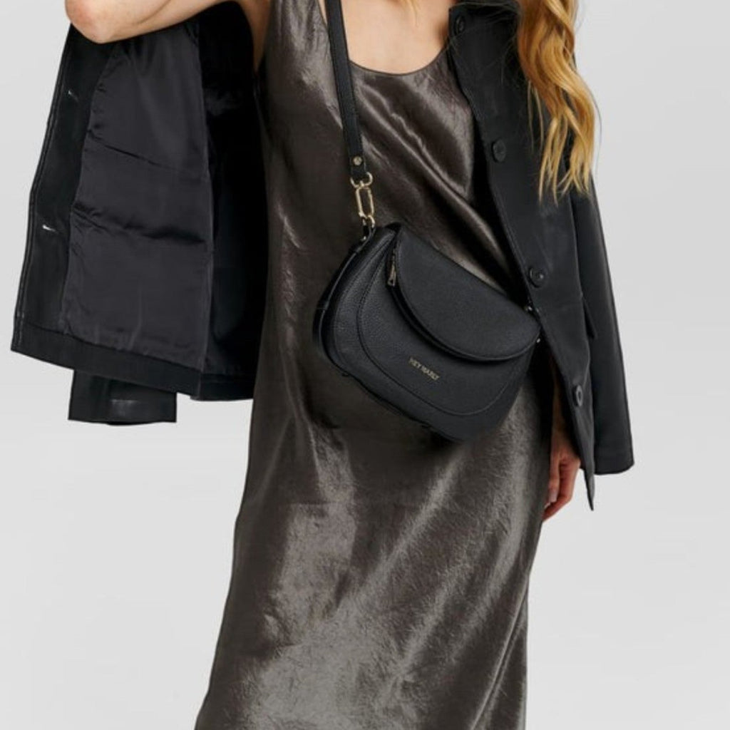 Lieblingstasche Big Sister black leather crossbody bag worn by a woman in a metallic dress and black jacket