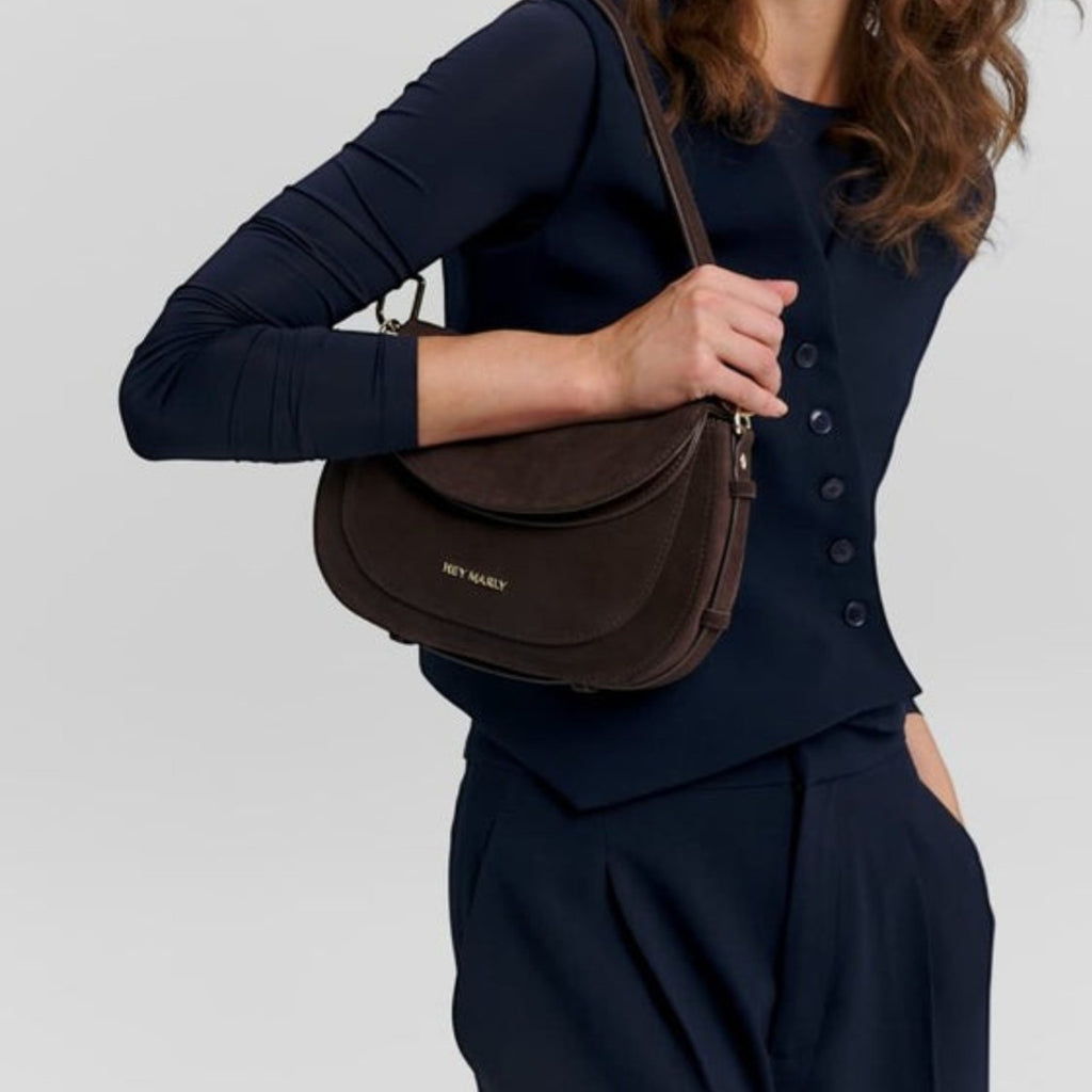 Lieblingstasche Big Sister Suede dark brown shoulder bag worn by a woman in a navy blue outfit