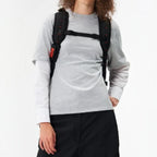 Lieblingstasche Duffel Pack in black worn as a backpack by a model, featuring adjustable straps and red accents.