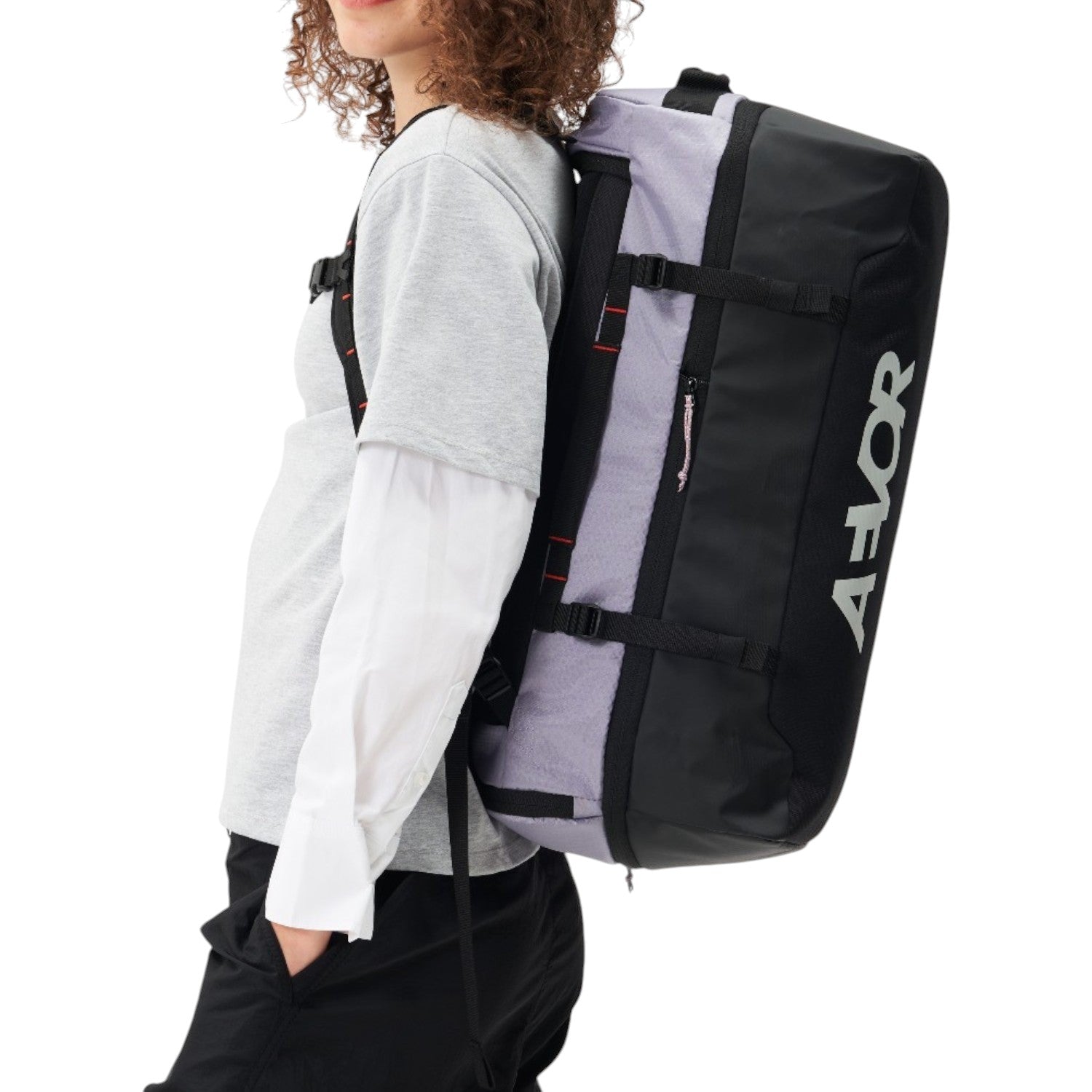 Lieblingstasche Duffel Pack in black and grey worn as a backpack by a woman against a white background