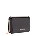 Lieblingstasche Flap Bag Ember, a black patent leather wallet with gold hardware and a zip closure.