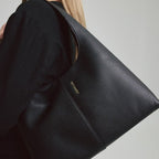 Lieblingstasche Alltime Lover M black pebbled leather hobo bag worn over the shoulder by a woman