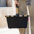 Lieblingstasche black carrybag shopping basket with a sturdy gold-tone aluminium handle held by a person outdoors