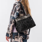 Lieblingstasche black shoulder bag with metallic silver trim and decorative stitching worn over the shoulder