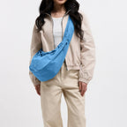 Lieblingstasche large blue moon bag worn by a woman with long dark hair, beige jacket and cream pants.