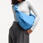 Lieblingstasche large blue nylon moon bag with ruffle detail and drawstring closure, worn by a model.