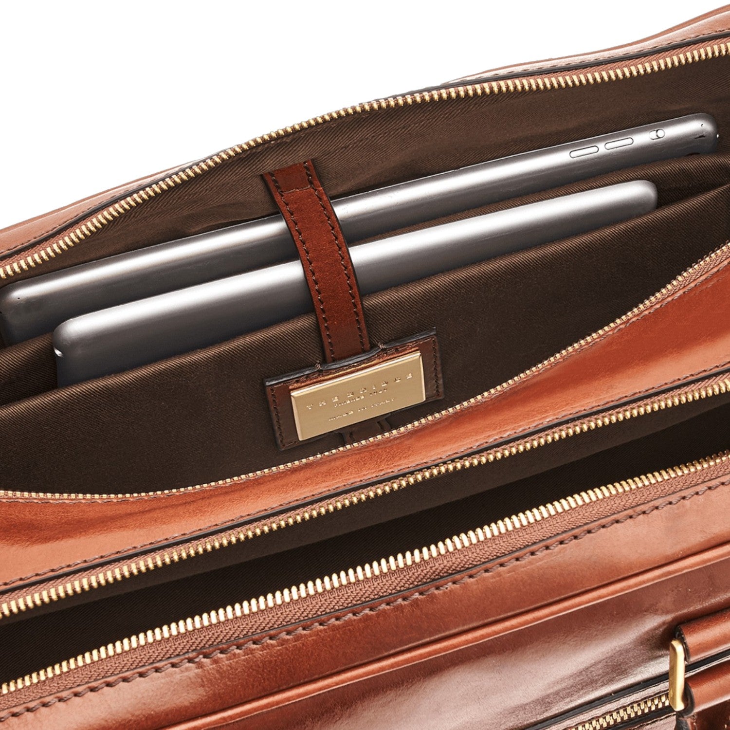 Lieblingstasche brown leather briefcase interior with two tablets secured by a leather strap.