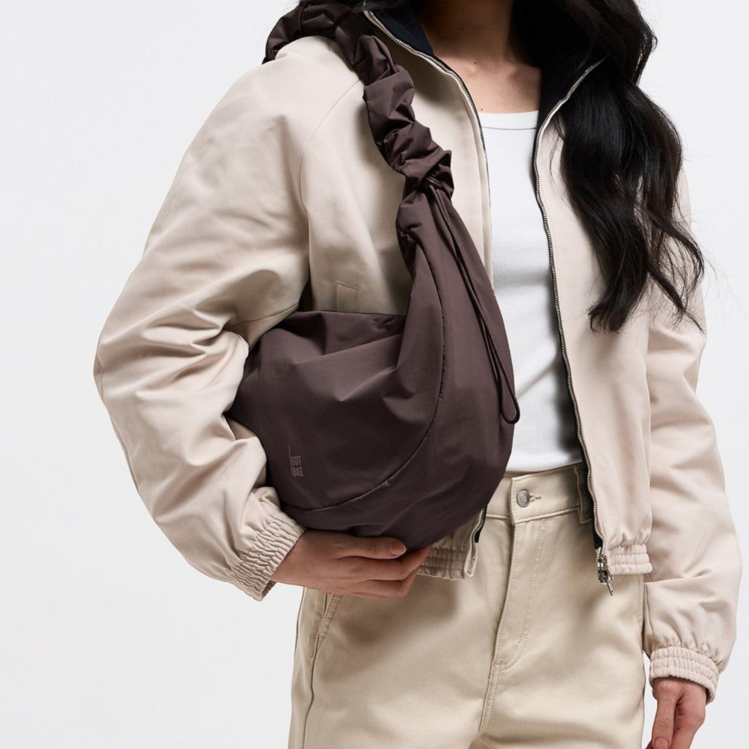 Lieblingstasche Moon Bag Ruffle Large in dark brown with a gathered shoulder strap worn by a woman in a beige jacket