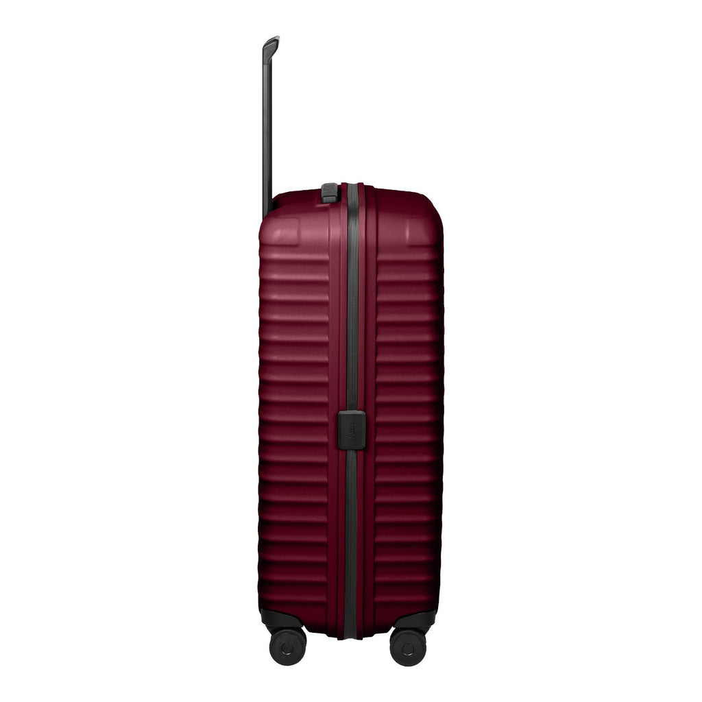 Lieblingstasche UPGRADE 4w Trolley L in deep burgundy with a ribbed hard shell and four wheels, side view.