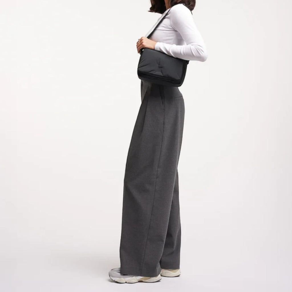 Model wearing a black Lieblingstasche Cloud Crossbody Bag made from water-resistant RE:NYNET material.