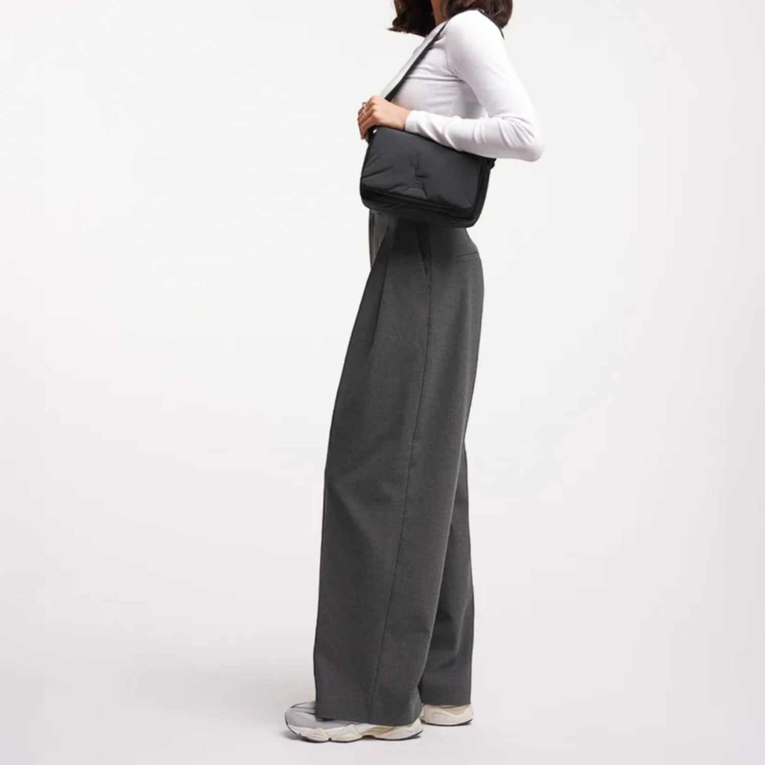 Model wearing a black Lieblingstasche Cloud Crossbody Bag made from water-resistant RE:NYNET material.