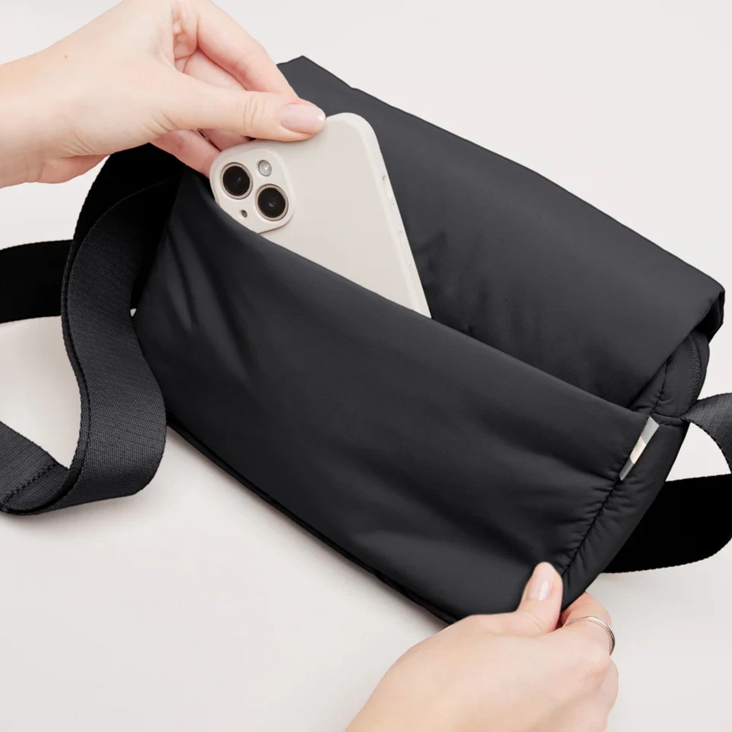 Lieblingstasche Cloud Crossbody Bag in black water-resistant RE:NYNET material with a phone in the front pocket
