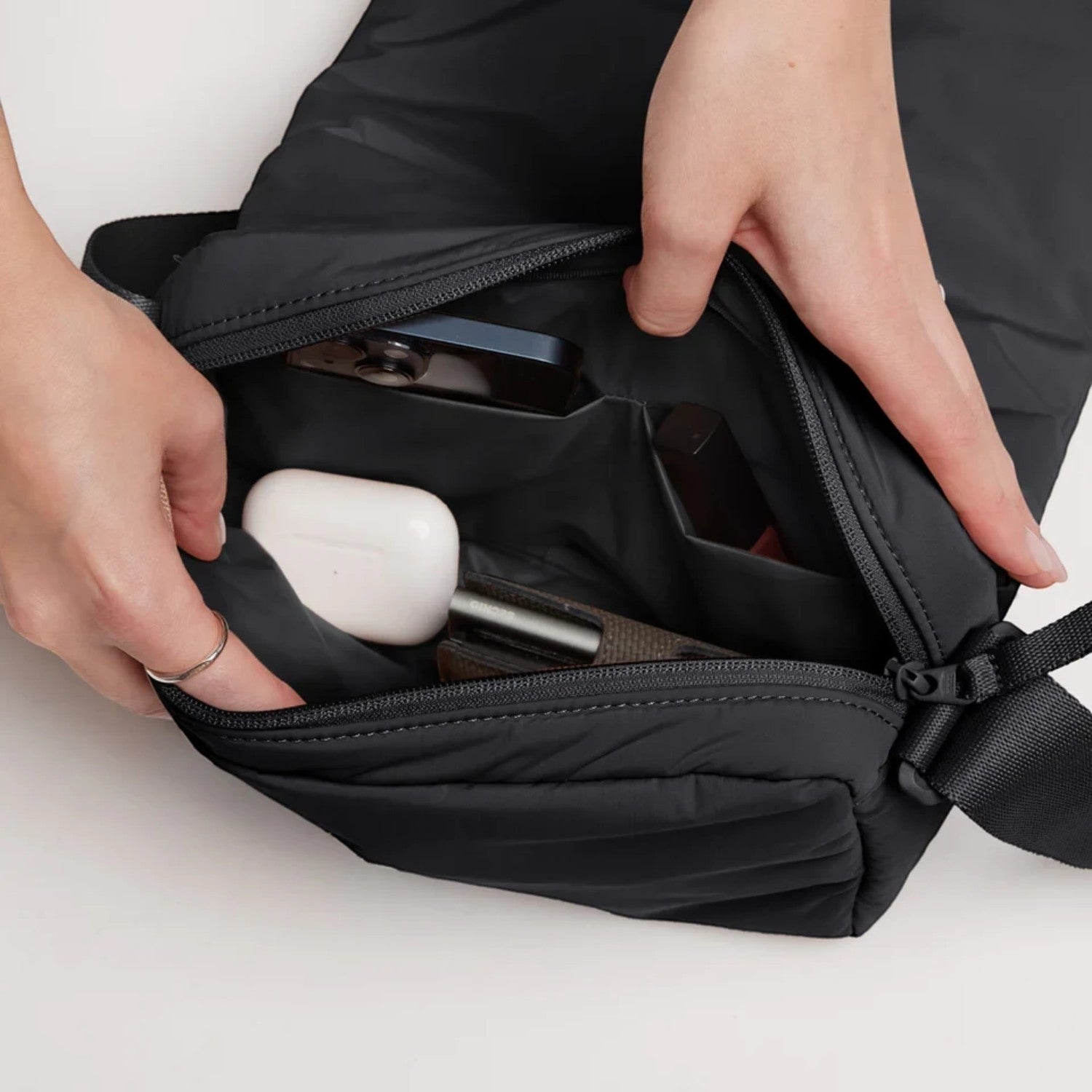Lieblingstasche Cloud Crossbody Bag in black with open main compartment showing organized pockets and personal items