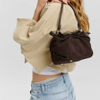 Lieblingstasche Cool Companion Suede S dark brown suede handbag with gathered detail carried by a blonde model