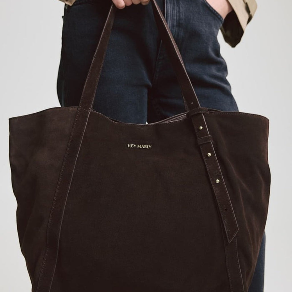 Lieblingstasche Pretty Wonder Suede dark brown leather tote bag with gold stud accents held by a woman
