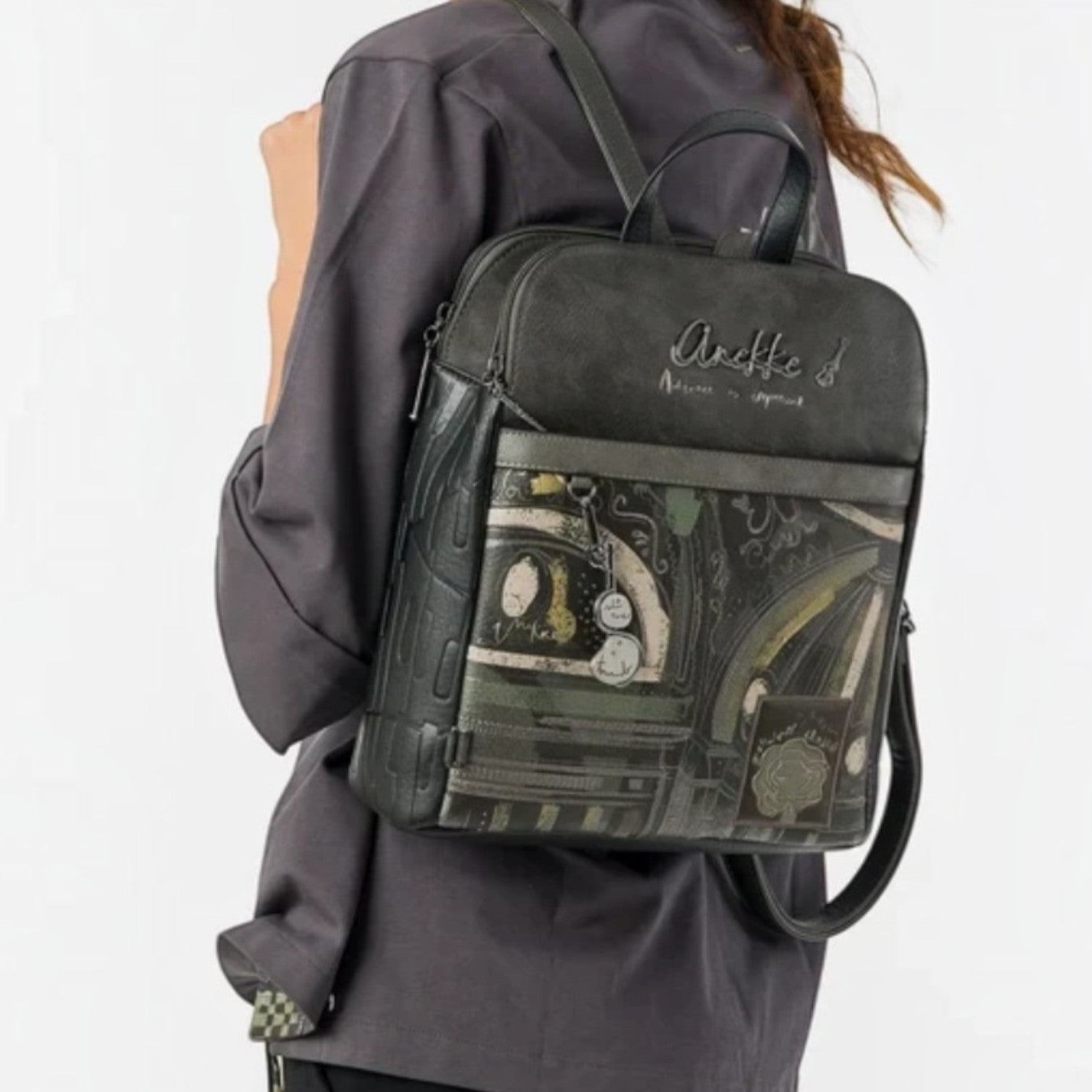 Woman wearing a Lieblingstasche dark grey patterned backpack with artistic graphic details on the front pocket