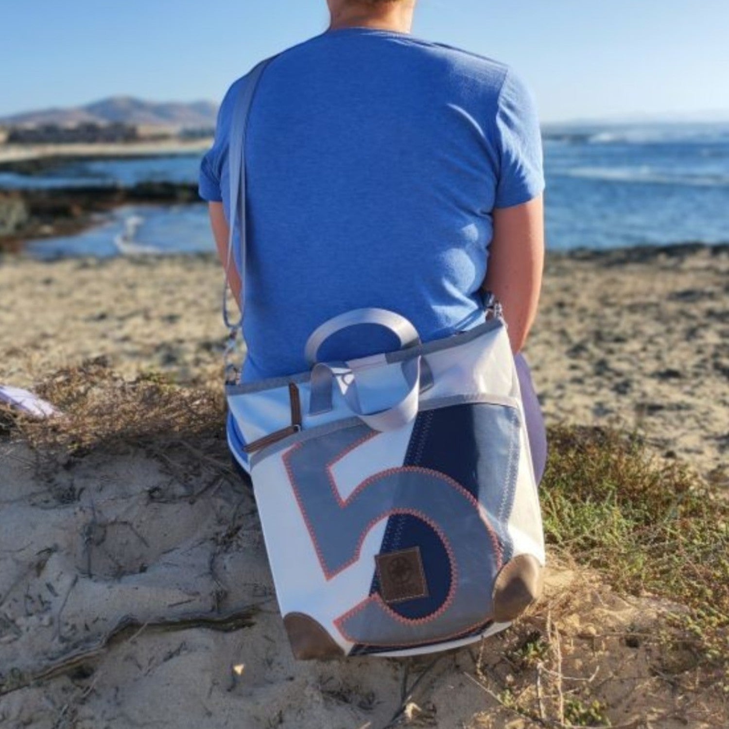 Lieblingstasche Deern Mini handbag made from recycled white and blue sailcloth with a number 5 print on the beach