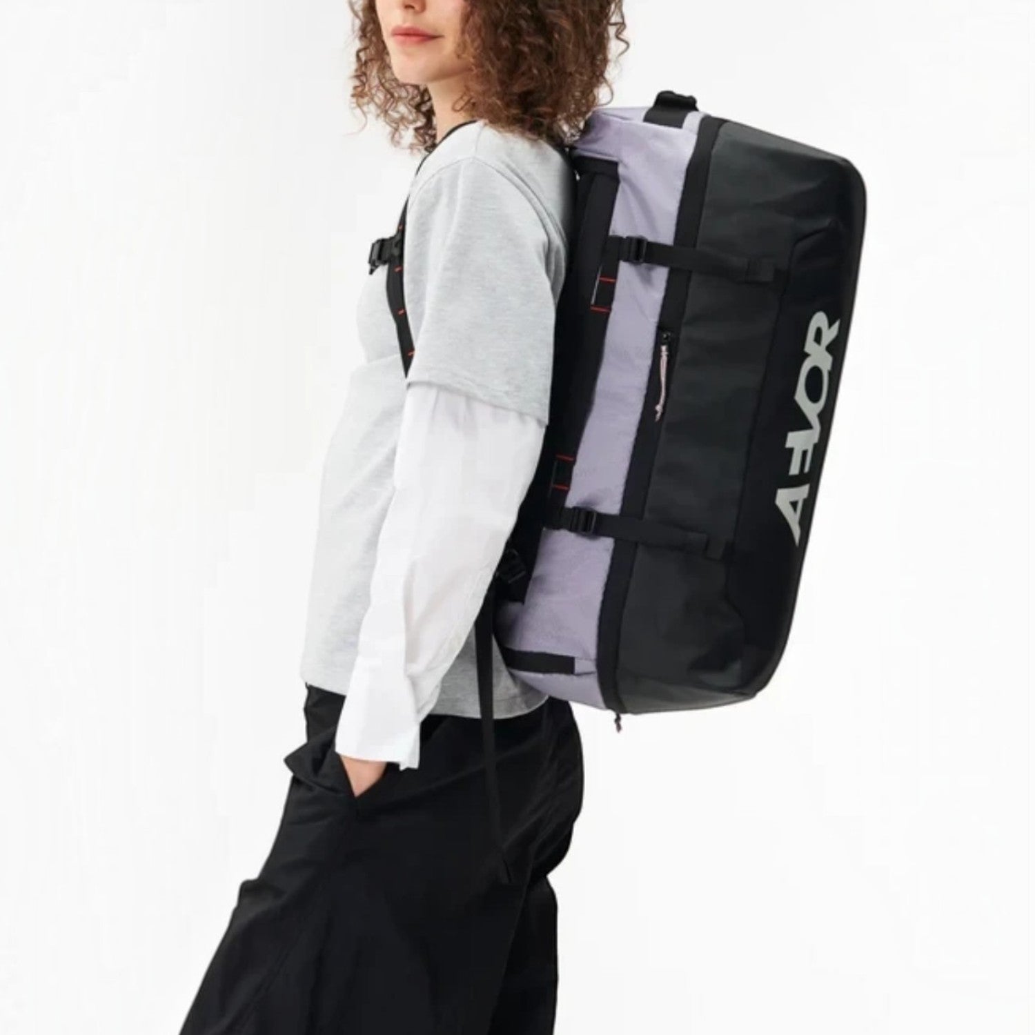 Lieblingstasche Duffel Pack in black and grey worn as a backpack by a woman for travel and sports