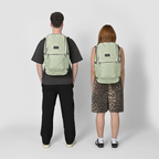 Two people wearing sage green Lieblingstasche Easy27 backpacks with a clean, modern design and front zip pockets.