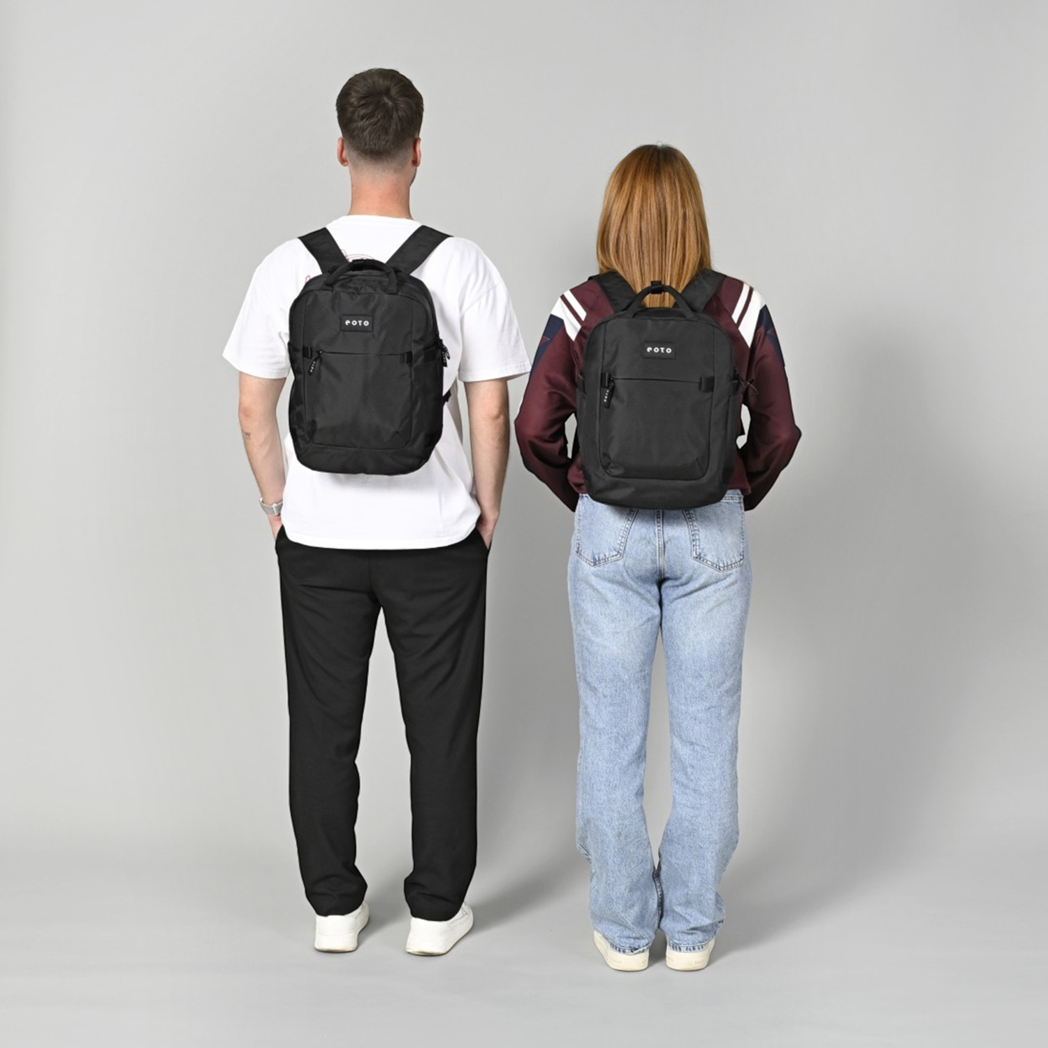 Lieblingstasche eoto Small16 black daypack worn by a man and a woman, showing the compact recycled material design.