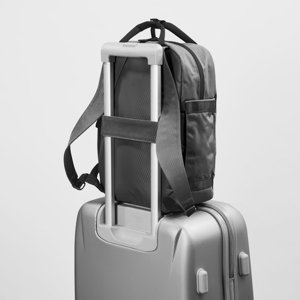 Lieblingstasche eoto Small16 compact daypack in grey, attached to a suitcase handle for travel convenience.