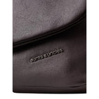 Close-up of the Lieblingstasche Fern bag in dark brown leather featuring the aunts & uncles metal logo plate