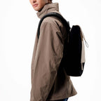 Man wearing a black and beige Kapten & Son Fyn backpack from Lieblingstasche, featuring a minimalist design.