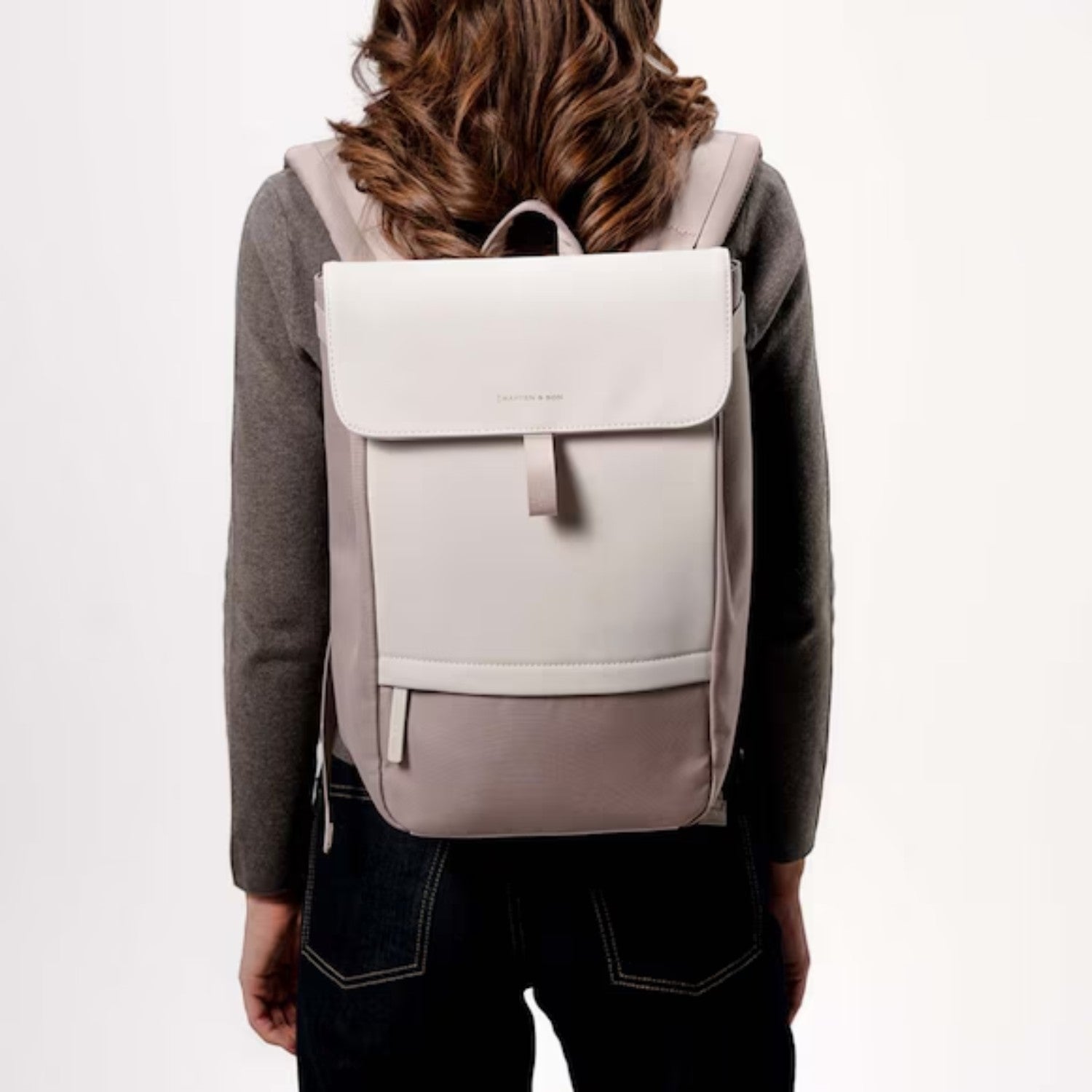 Lieblingstasche Kapten & Son Fyn backpack in beige with minimalist design, worn by a woman from the back view.