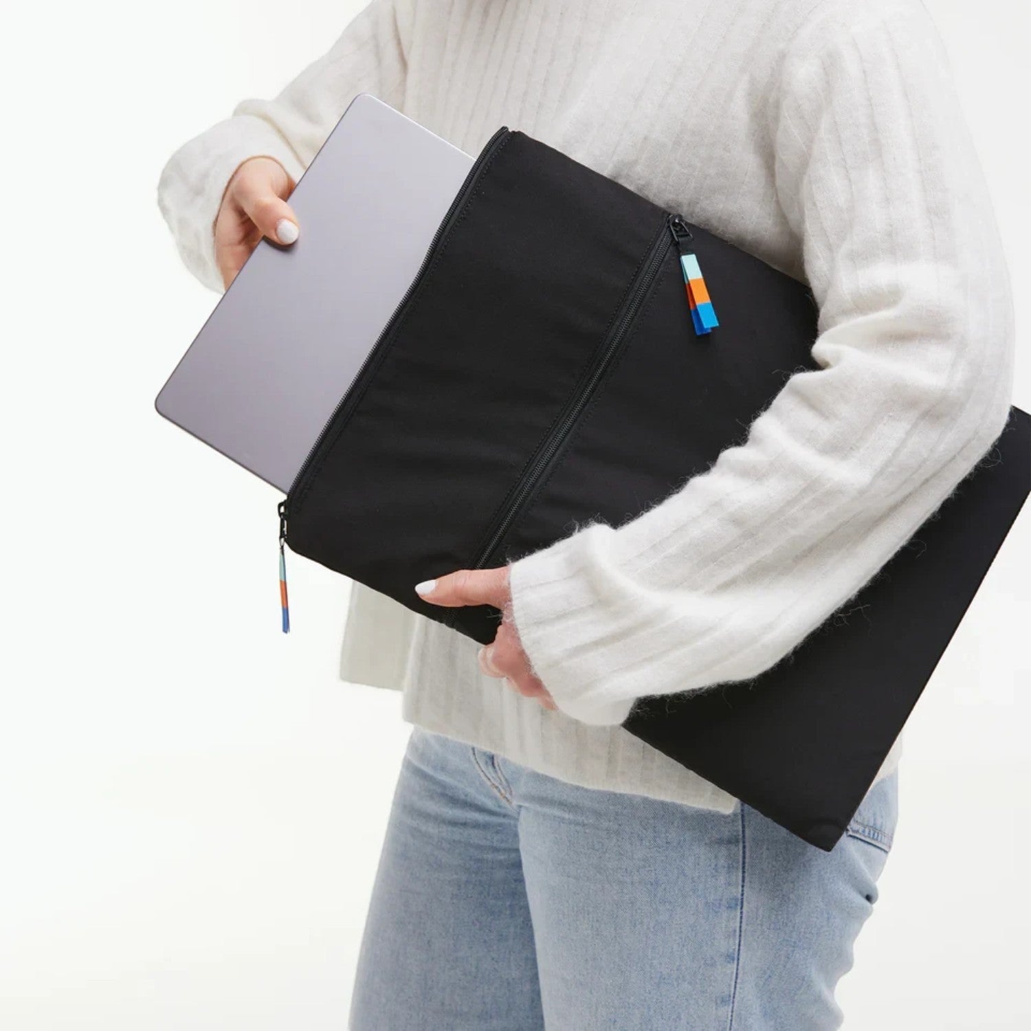 Lieblingstasche GOT BAG black laptop sleeve with a silver laptop being inserted by a person in a white sweater