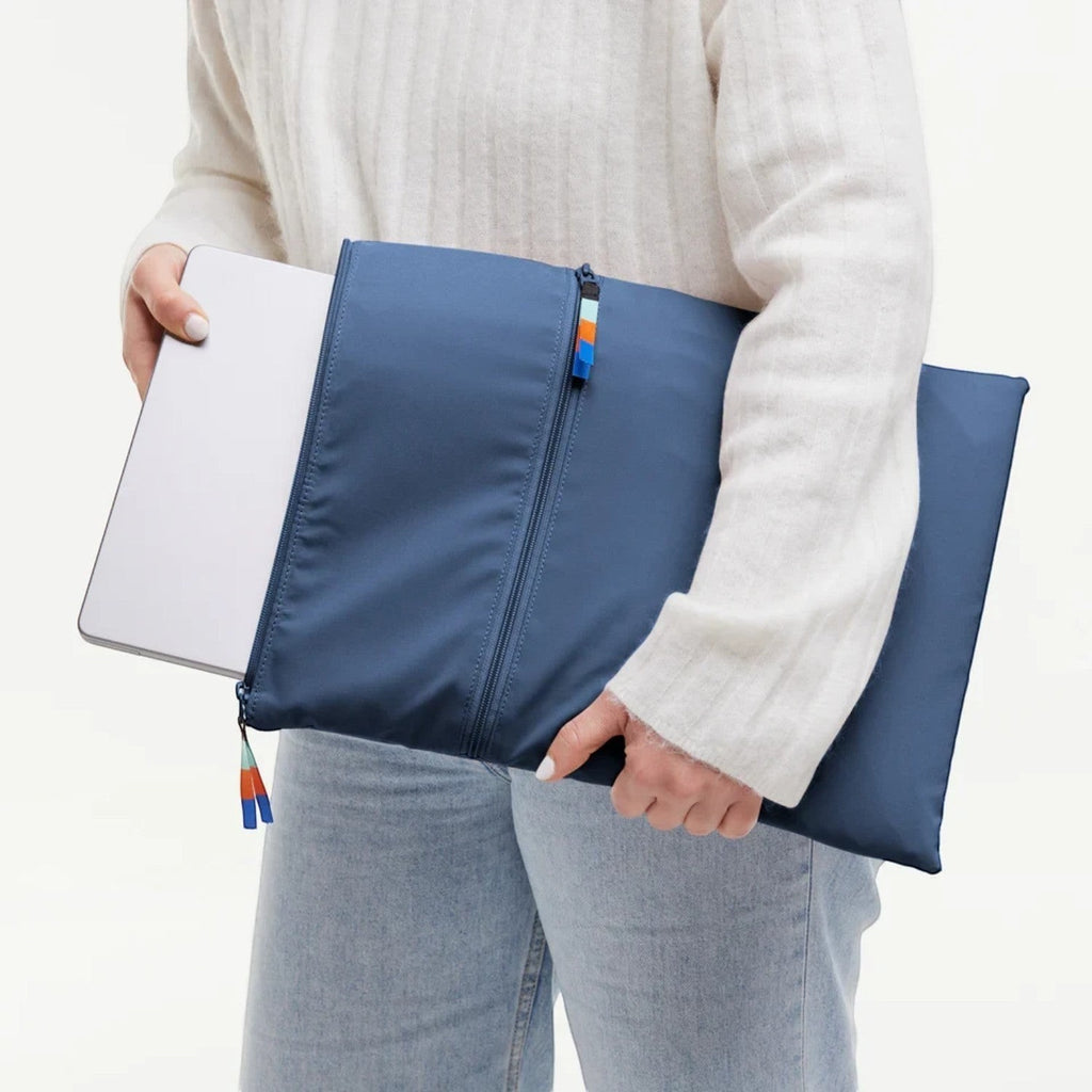 Lieblingstasche GOT BAG blue laptop sleeve with zipper and colorful pull tabs held by a person