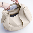 Lieblingstasche GOT BAG curved beige shoulder bag with wide strap and interior zip pocket being opened by hand