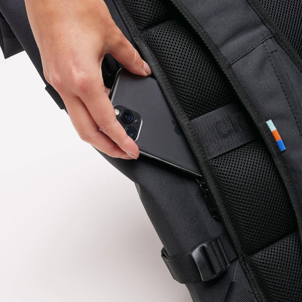 Lieblingstasche GOT BAG Rolltop 2.0 backpack showing a hand placing a smartphone into the padded back security pocket
