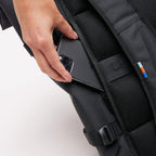 Lieblingstasche GOT BAG Rolltop 2.0 backpack showing a hand placing a smartphone into the padded back security pocket