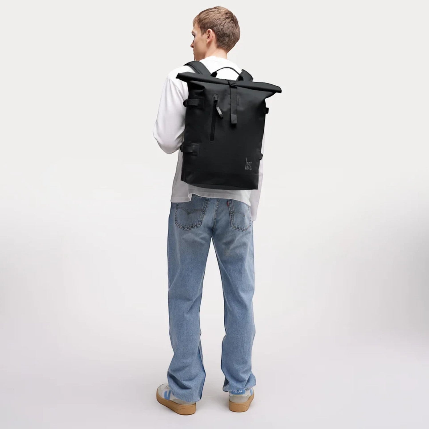 Lieblingstasche GOT BAG Rolltop 2.0 backpack in black worn by a man in a white long-sleeve shirt and blue jeans