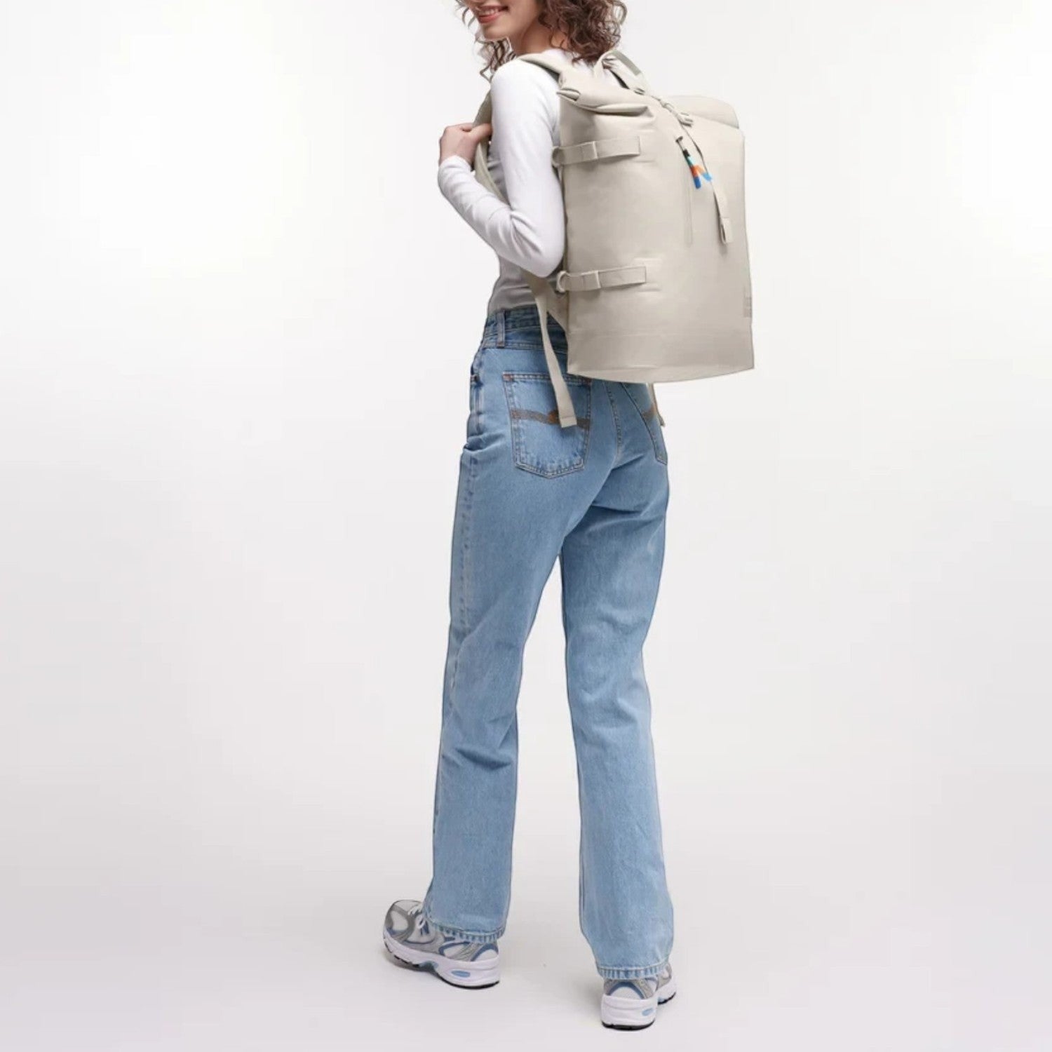 Lieblingstasche GOT BAG Rolltop 2.0 backpack in beige worn by a woman with curly hair against a white background