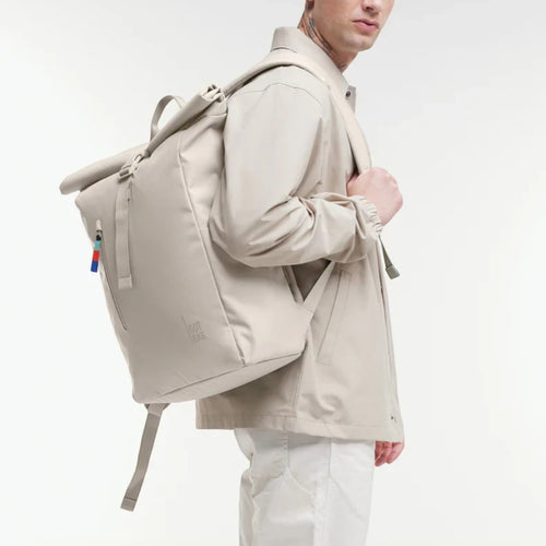 Lieblingstasche GOT BAG Rolltop Easy backpack in beige worn by a man in a matching jacket against a white background