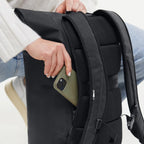 Lieblingstasche GOT BAG Rolltop Lite 2.0 black backpack with a person placing a phone in the side zipper pocket.