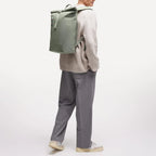 Lieblingstasche GOT BAG Rolltop Lite 2.0 sage green backpack worn by a man in a casual sweater and trousers