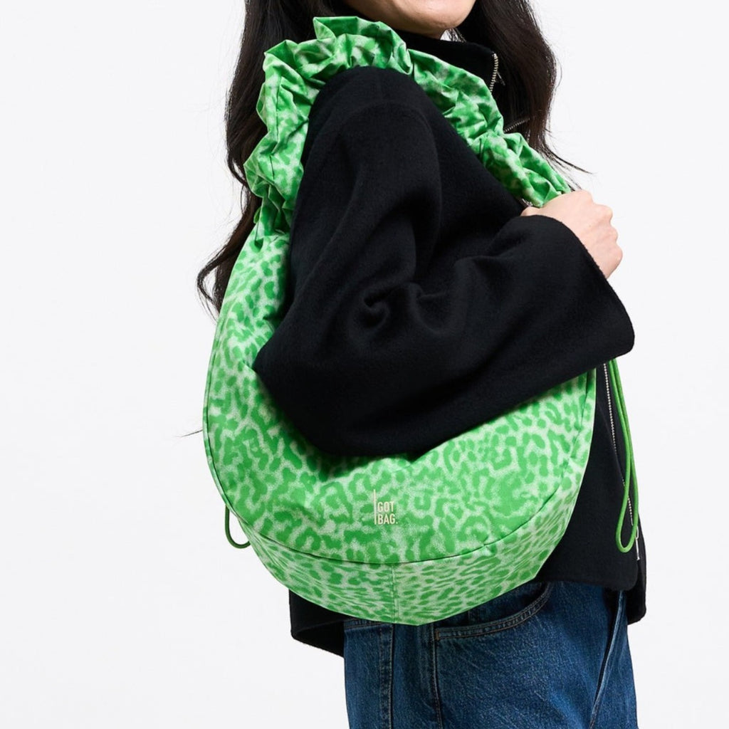 Lieblingstasche Moon Bag Ruffle Large in green leopard print worn over the shoulder by a smiling woman