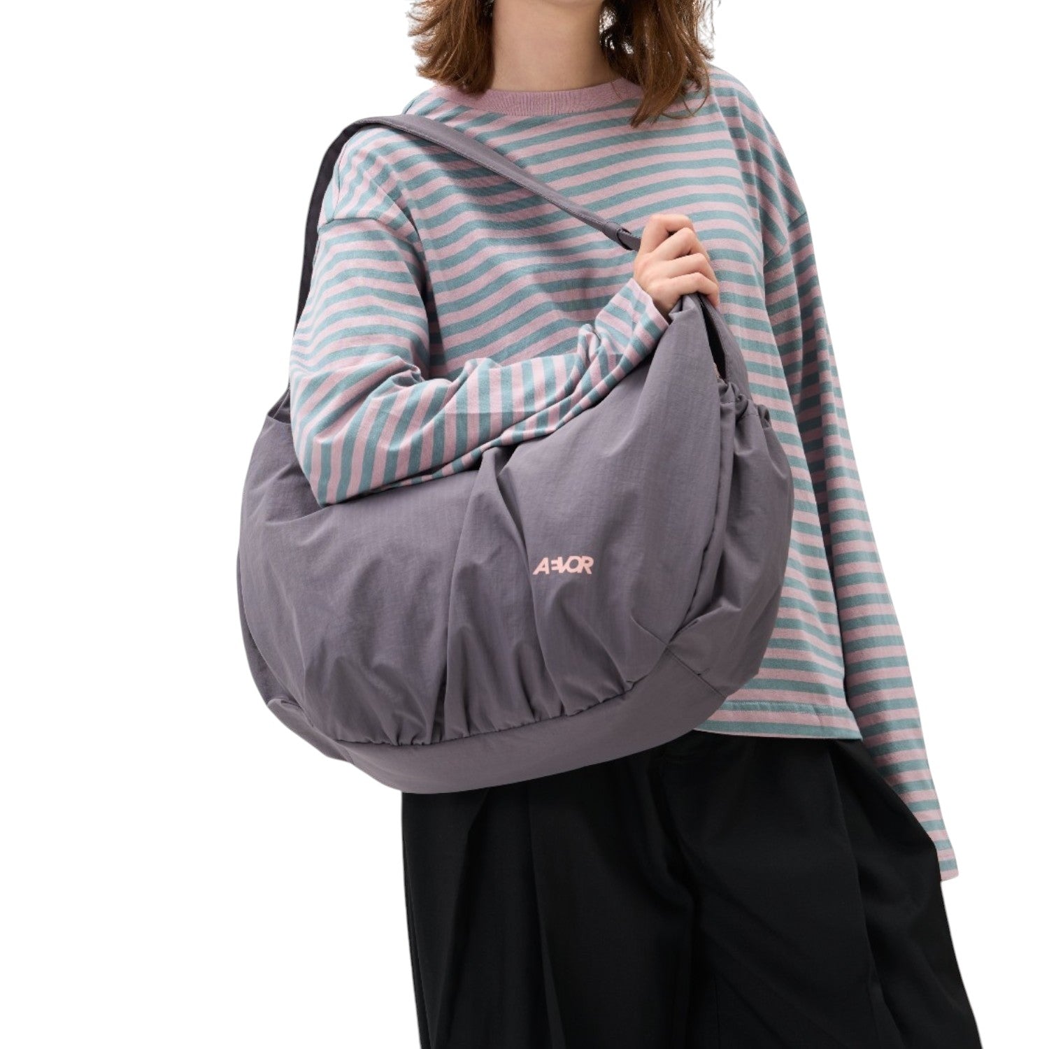 Lieblingstasche slouchy grey shoulder bag with pink logo worn by a model in a striped long-sleeve shirt